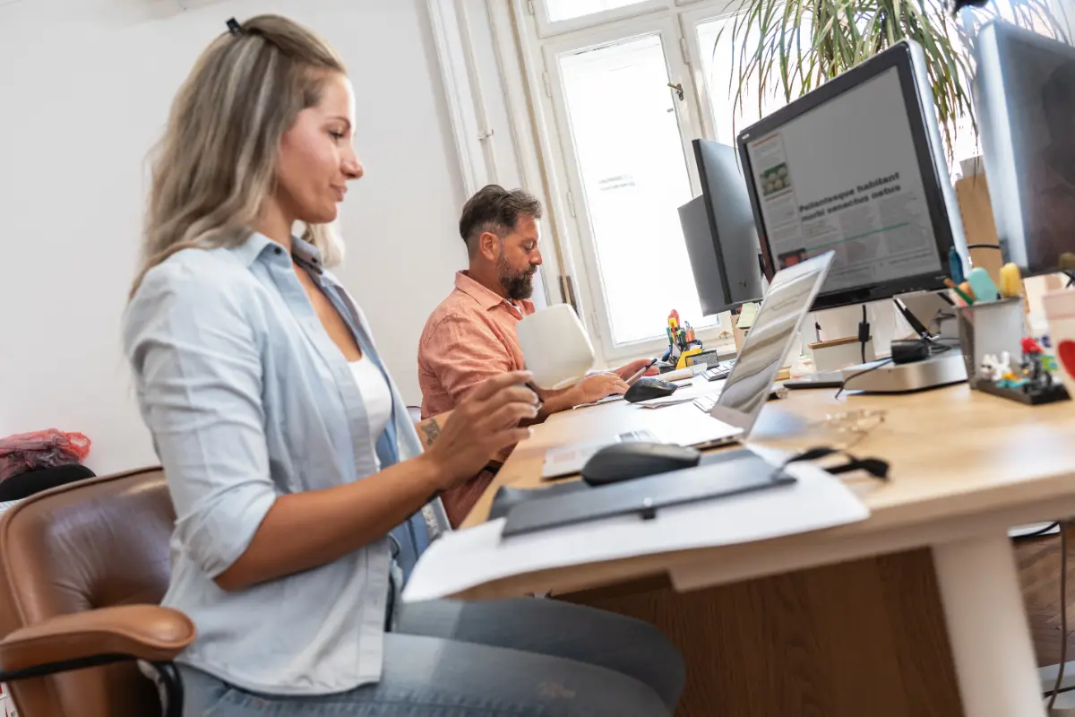 Close up shot of woman typing on a laptop in a office