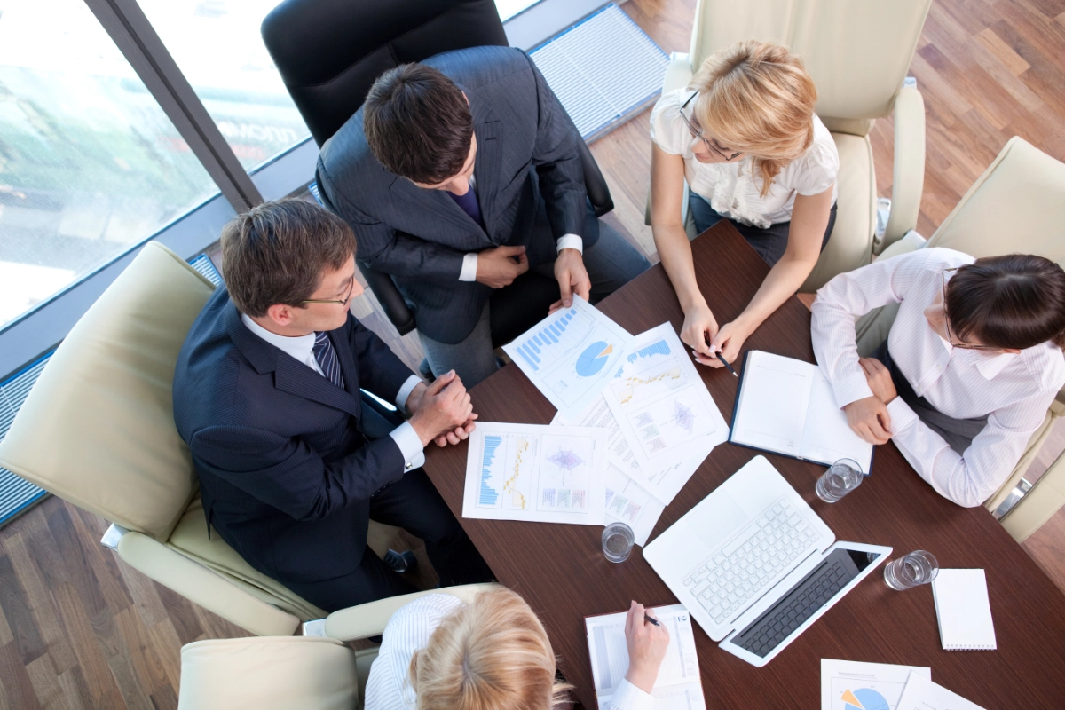 overhead shot of business people working in the office looking at graphs and data