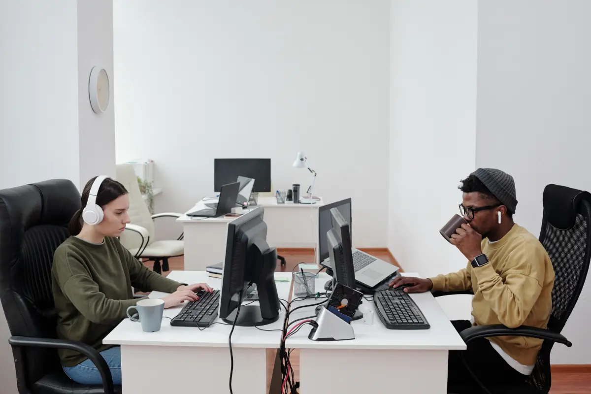 wide shot of two people in the office working on computers